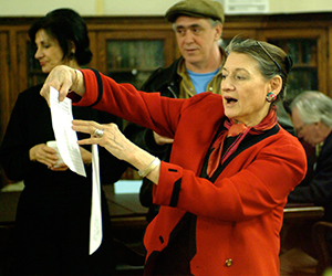 woman holding paper and speaking